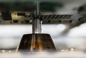 Machine de soudage sélectif pour le assemblage cartes électroniques qui ont déjà des composants SMD sur un côté. Les cartes électroniques sont maintenues au-dessus du jet de soudure par un cadre de soudure spécial.