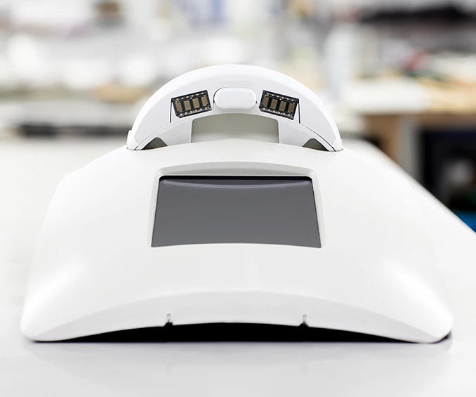 Image d'un exemple de station de charge intégrée, contenue dans un boîtier en plastique blanc avec un écran TFT intégré. Cet exemple illustre les compétences de CLOOS electronic dans la construction complexe de boîtiers et la réalisation de tests fonctionnels à 100%, garantissant la fiabilité et la plus haute qualité dans la fabrication du produit final.