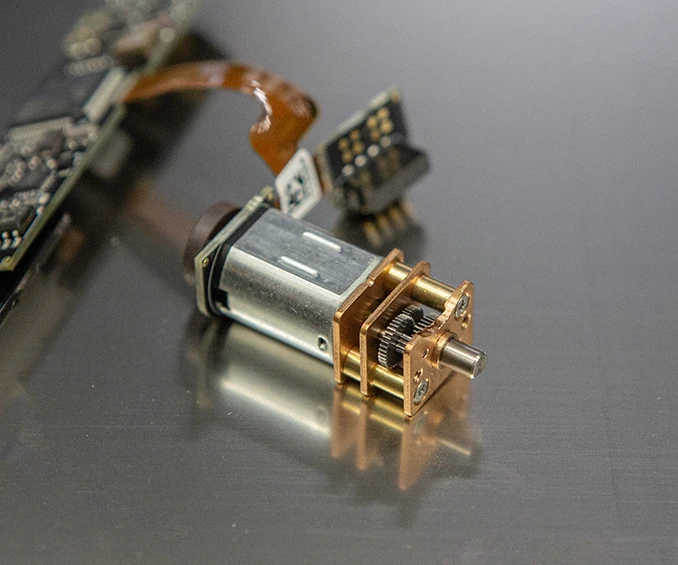 Image d'un exemple d'intégration d'une PCBA Flex-Rigid équipée en SMD avec un micro moteur, testée fonctionnellement à 100%, spécifiquement pour une utilisation en technologie médicale. Ceci illustre la capacité de CLOOS electronic à combiner des technologies de haute précision et à fournir des solutions fiables en ingénierie de micro-précision, adaptées aux applications médicales exigeantes.